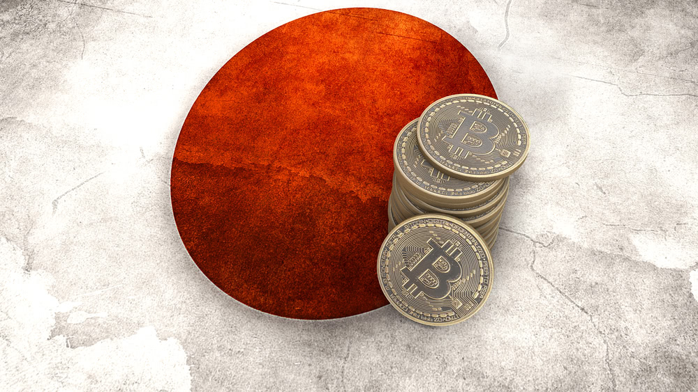 A pile of Bitcoin crypto coins stands on the flag of Japan