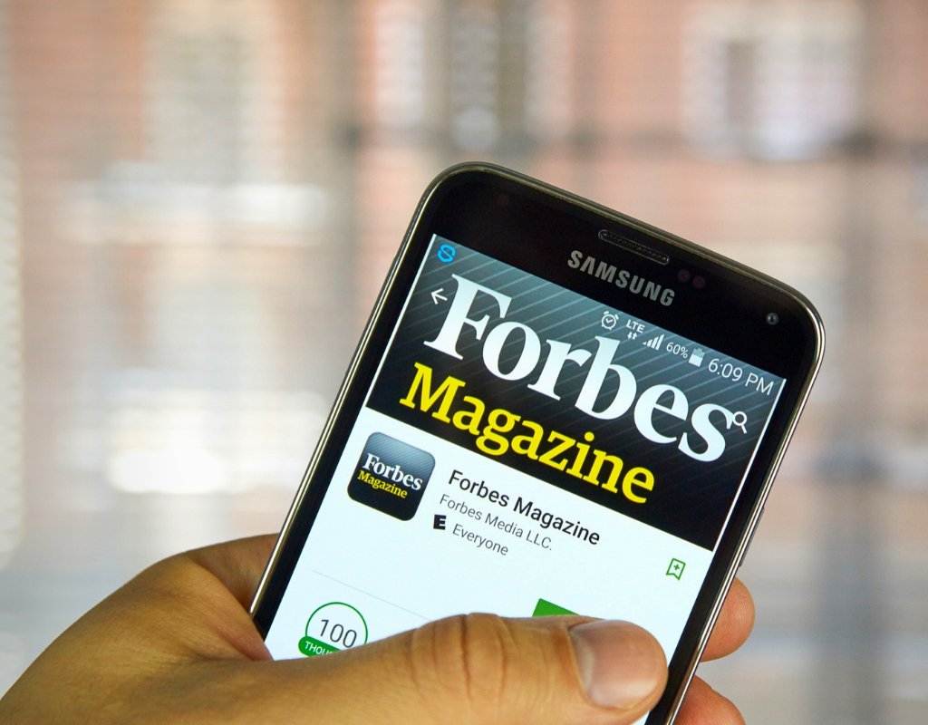 Phone with Forbes Magazine application open.