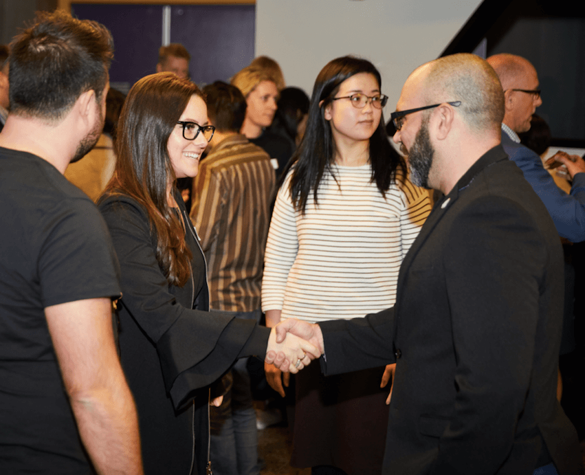 Kimberley Winter shaking hands at a blockchain conference.