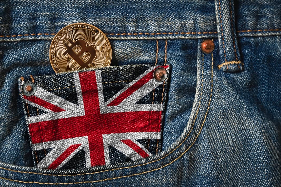 Bitcoin in pocket on a pair of jeans with the flag of the United Kingdom