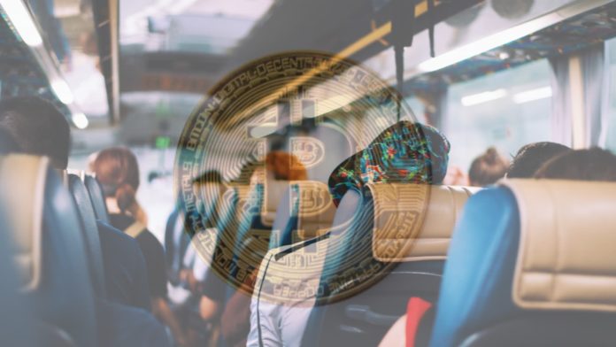 image of bitcoin coin over an image with people on the bus